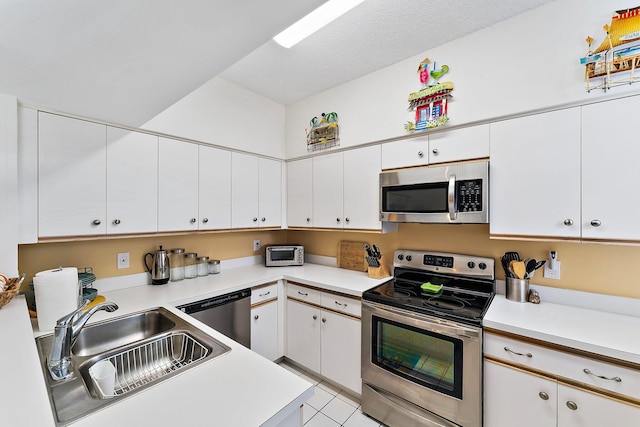 kitchen featuring light countertops, appliances with stainless steel finishes, a sink, and white cabinetry