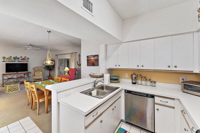 kitchen with light countertops, visible vents, a sink, dishwasher, and a peninsula