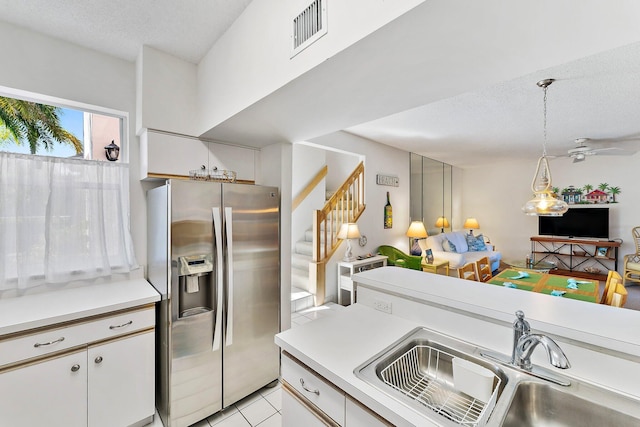 kitchen featuring visible vents, light countertops, a sink, and stainless steel fridge with ice dispenser