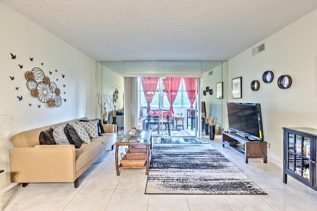 tiled living area with visible vents and a textured ceiling