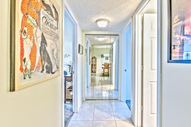 hall featuring tile patterned flooring and a textured ceiling