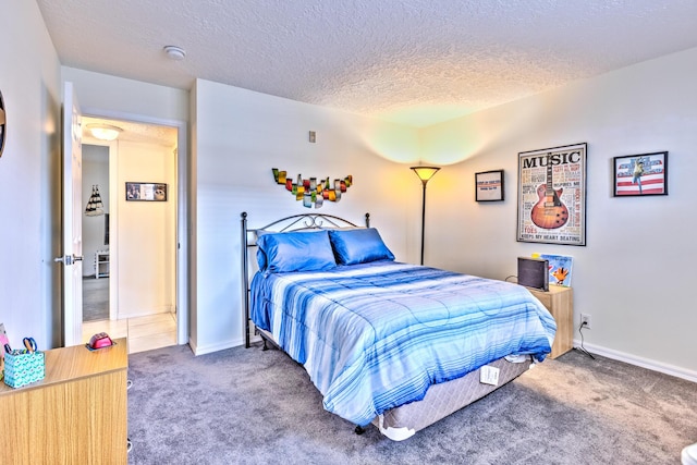 carpeted bedroom featuring baseboards and a textured ceiling