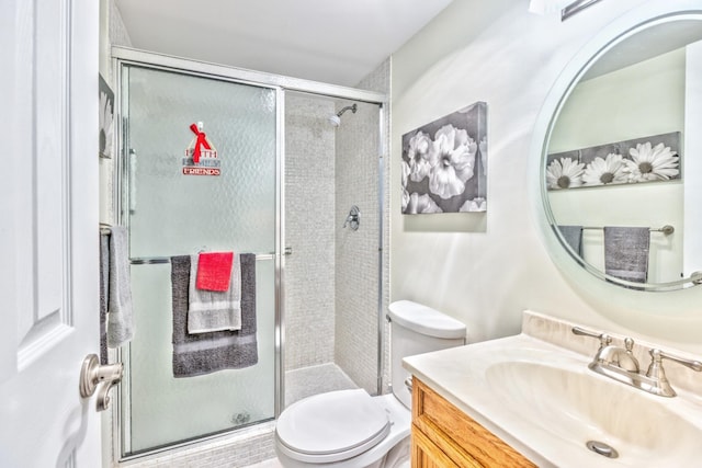 bathroom with vanity, a shower stall, and toilet