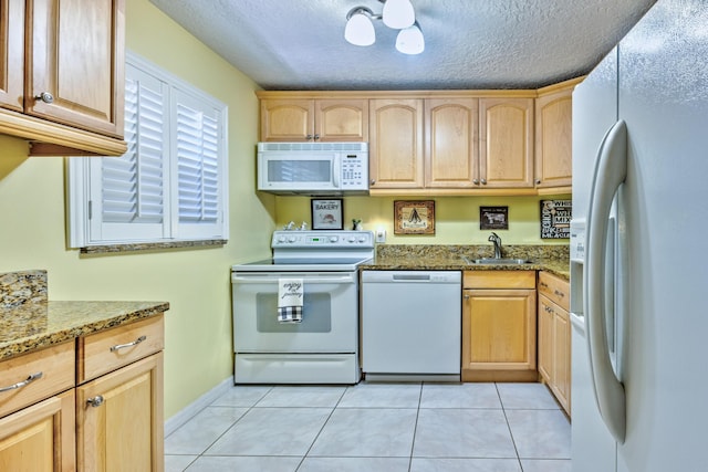 kitchen featuring light tile patterned floors, white appliances, stone counters, and light brown cabinets