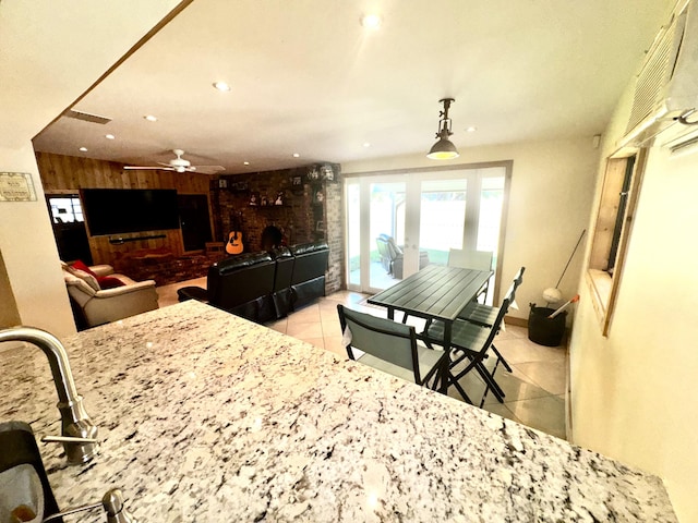 kitchen with a fireplace, recessed lighting, ceiling fan, wooden walls, and tile patterned flooring