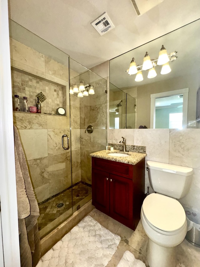 bathroom featuring a stall shower, visible vents, tile walls, and vanity