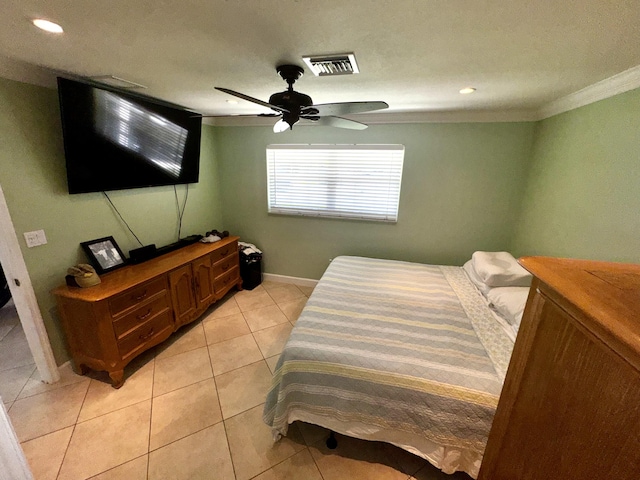 bedroom featuring light tile patterned floors, visible vents, ornamental molding, a ceiling fan, and baseboards