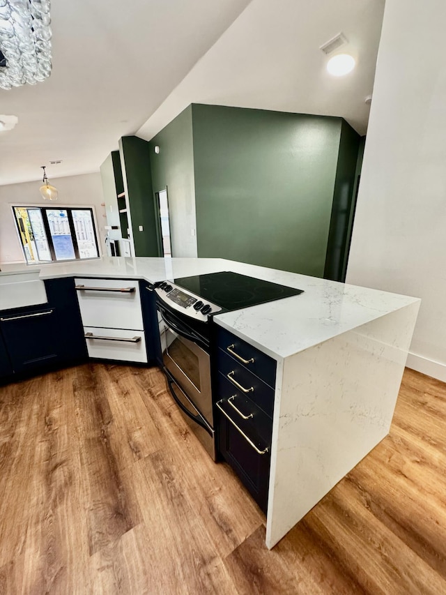 kitchen with visible vents, light wood-style flooring, light stone counters, stainless steel range with electric stovetop, and a warming drawer