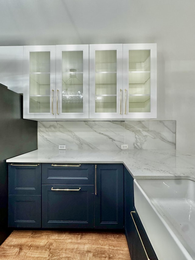 bar featuring tasteful backsplash, freestanding refrigerator, and a sink