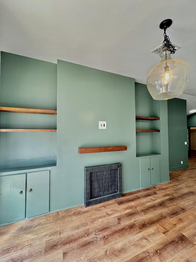 unfurnished living room featuring a fireplace and wood finished floors