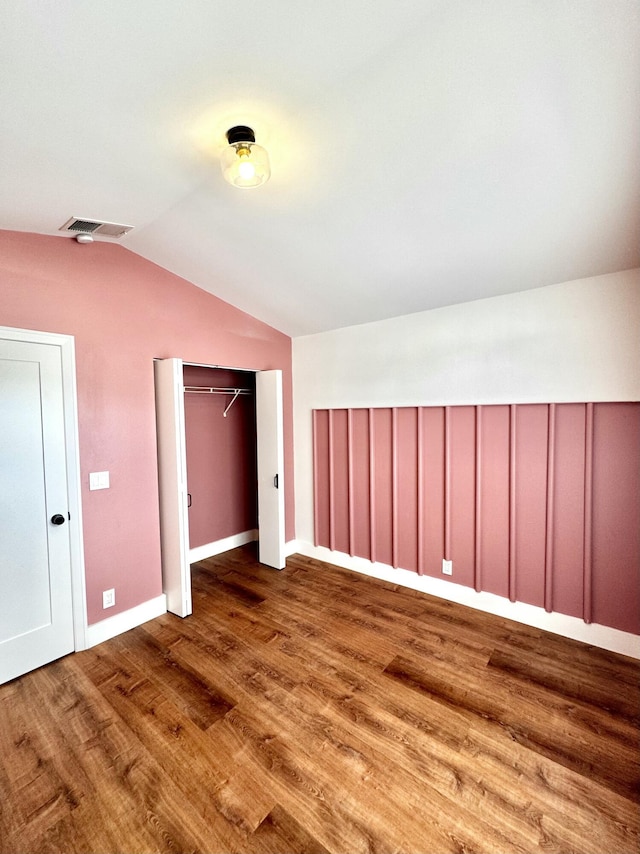 additional living space featuring lofted ceiling, wood finished floors, visible vents, and baseboards