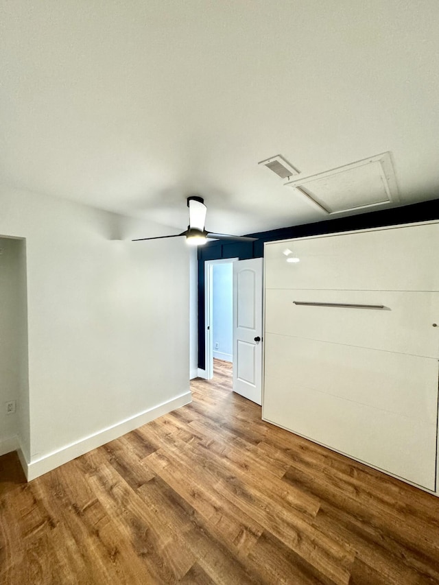 empty room with baseboards, ceiling fan, visible vents, and wood finished floors