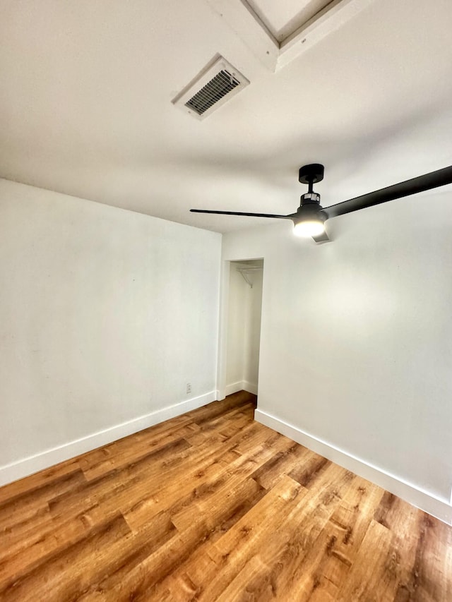 empty room with ceiling fan, baseboards, visible vents, and light wood-style floors