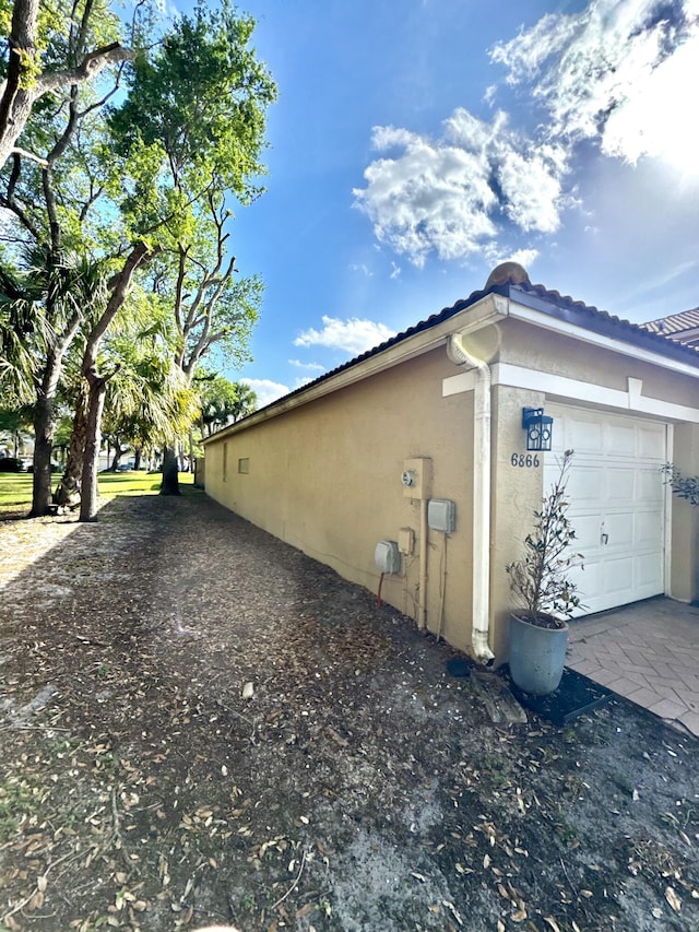 view of property exterior with a garage and stucco siding