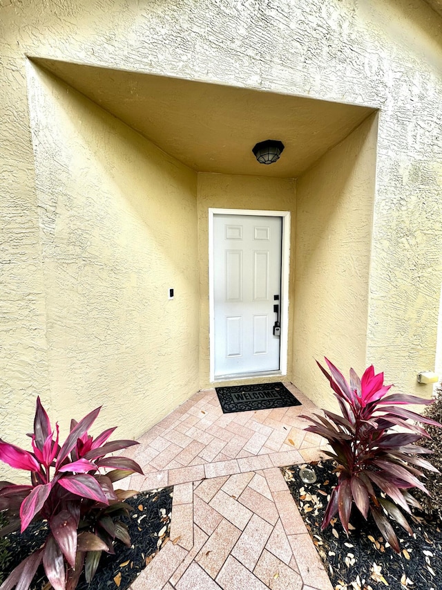 entrance to property featuring stucco siding