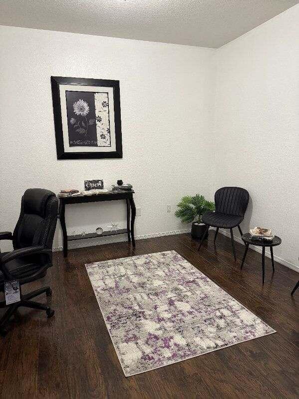 office area featuring baseboards, dark wood finished floors, and a textured ceiling