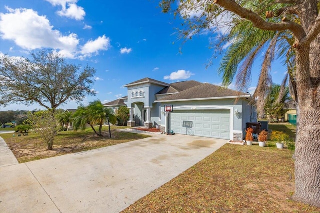 view of front of home featuring a garage, a front yard, concrete driveway, and stucco siding