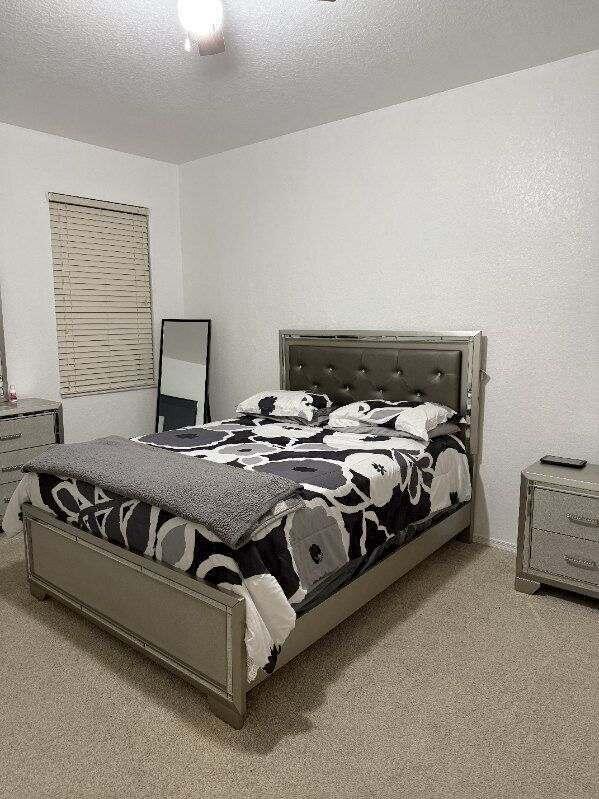 carpeted bedroom featuring a textured ceiling