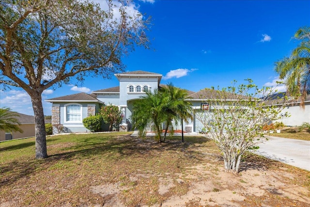 view of front of property with a garage, stucco siding, concrete driveway, and a front yard