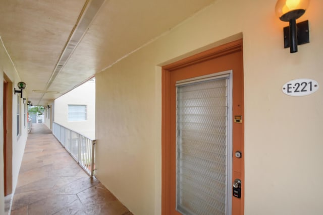 entrance to property featuring a balcony and stucco siding