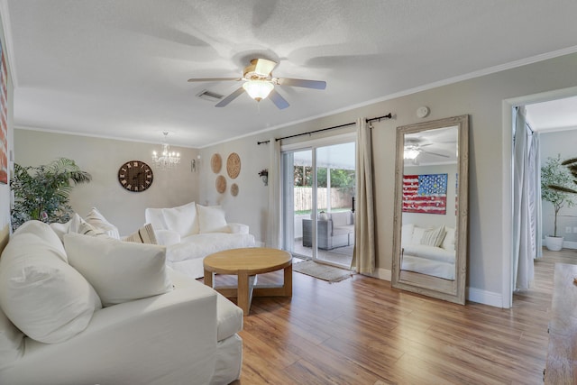 living area with crown molding, baseboards, visible vents, and light wood-style floors