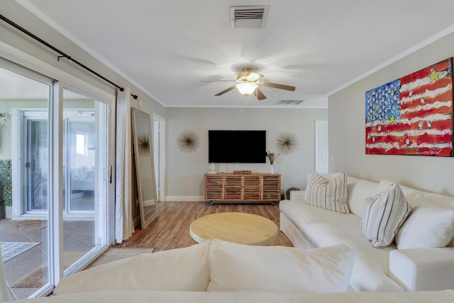 living room with ornamental molding, wood finished floors, and visible vents