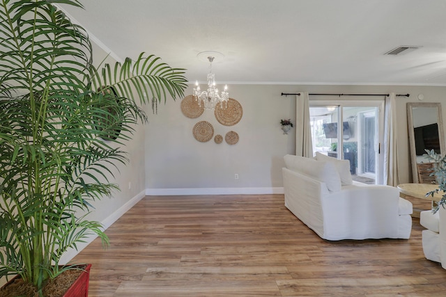 living room with light wood finished floors, ornamental molding, visible vents, and baseboards