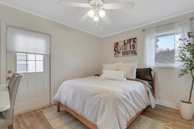 bedroom featuring multiple windows, wood finished floors, and crown molding