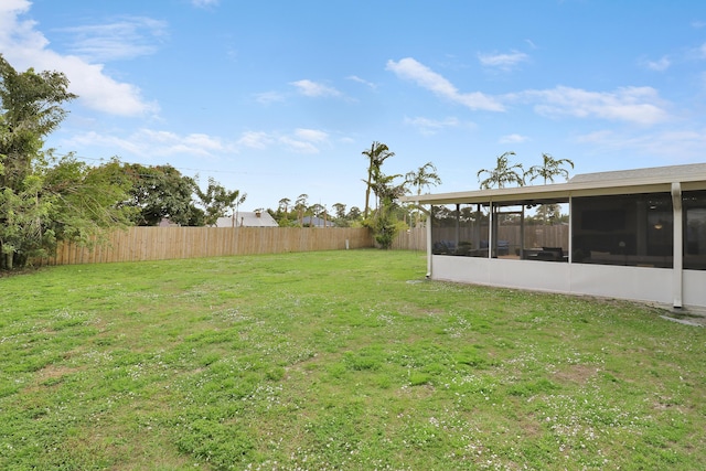 view of yard with fence and a sunroom