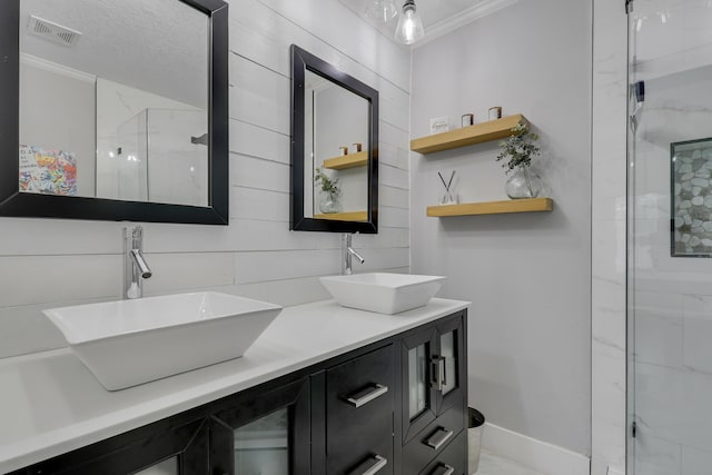 full bathroom with double vanity, crown molding, visible vents, and a sink