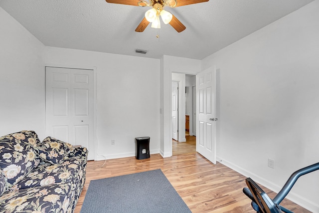 interior space with light wood-type flooring, visible vents, a textured ceiling, and baseboards