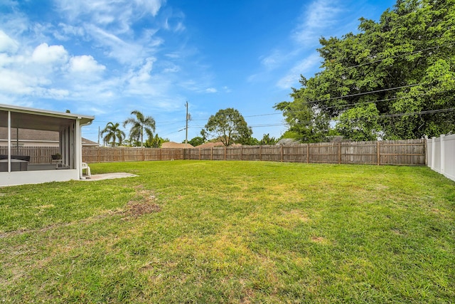 view of yard featuring a sunroom and a fenced backyard