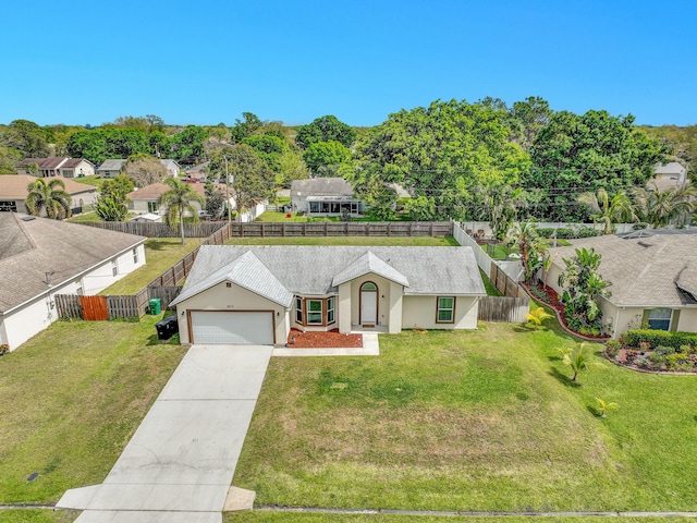 view of front of house with a garage, fence, driveway, stucco siding, and a front yard