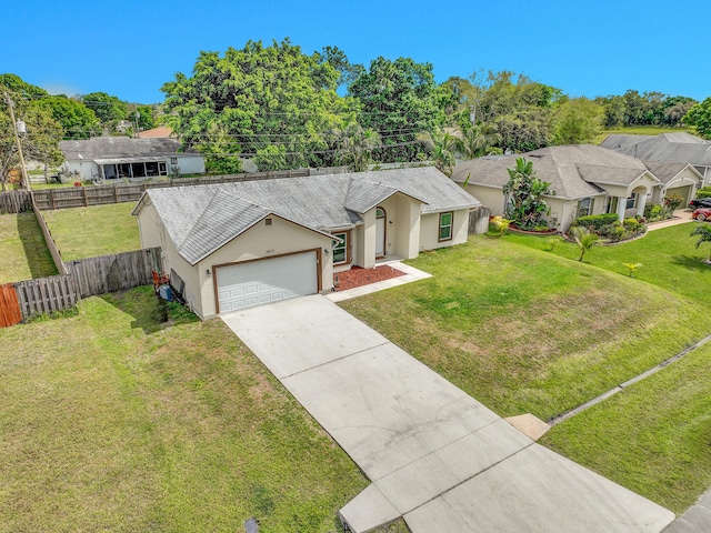 ranch-style house featuring an attached garage, fence, driveway, stucco siding, and a front yard