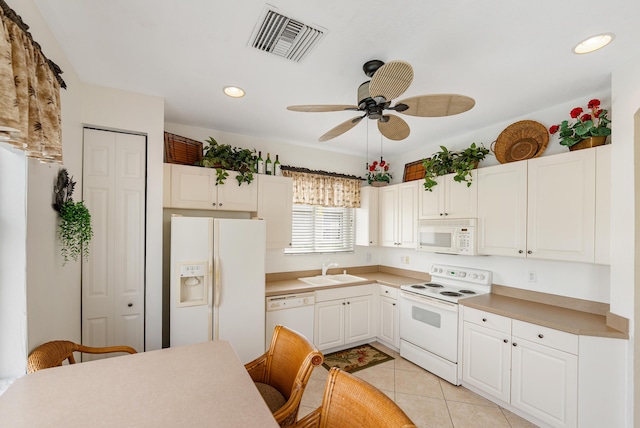 kitchen with light tile patterned floors, recessed lighting, white appliances, a sink, and visible vents