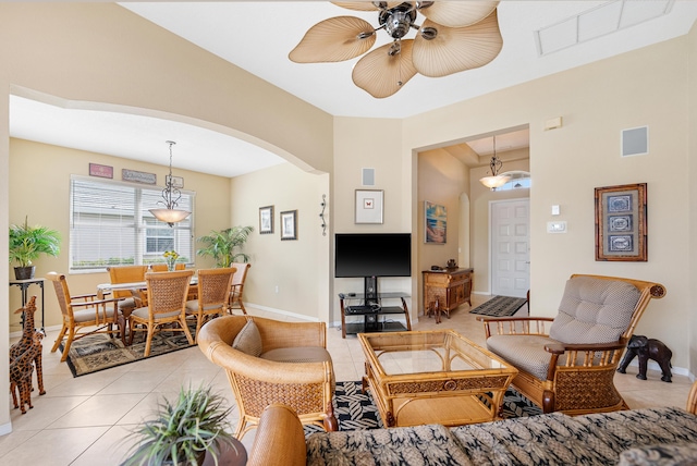 living area with light tile patterned floors, arched walkways, and visible vents