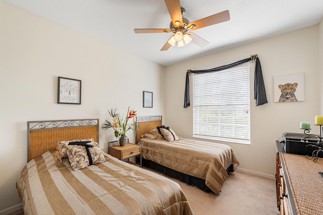 bedroom with a ceiling fan, light carpet, and baseboards