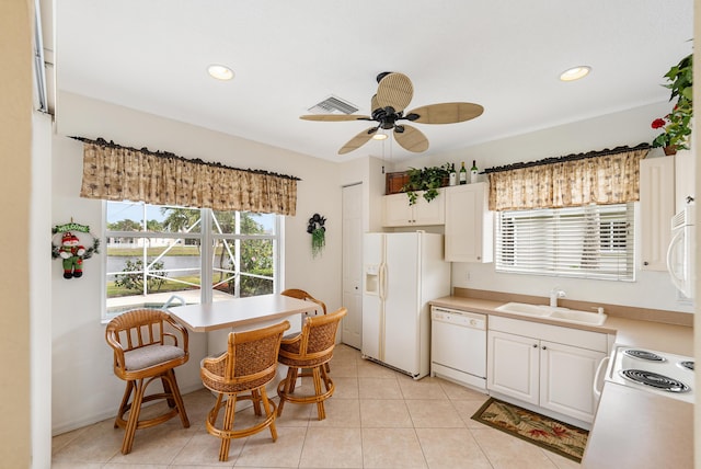 kitchen featuring white appliances, white cabinetry, a wealth of natural light, and a sink