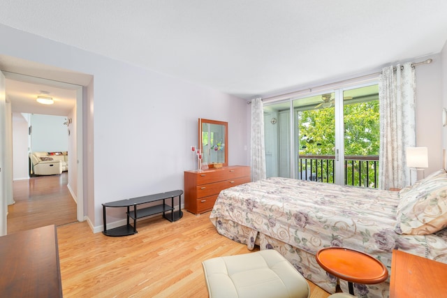 bedroom featuring baseboards, wood finished floors, and access to exterior