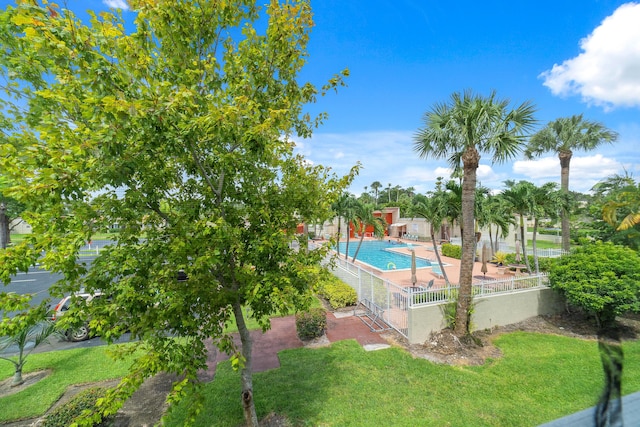 pool featuring a patio area, fence, and a lawn