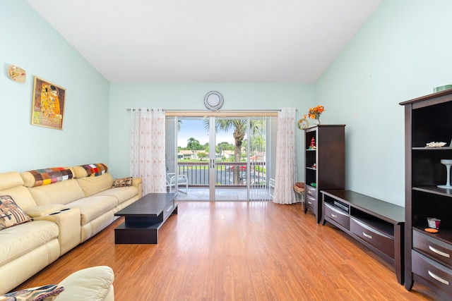 living room with light wood-type flooring, lofted ceiling, and french doors