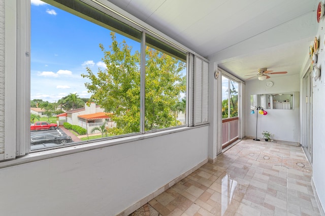 unfurnished sunroom with ceiling fan