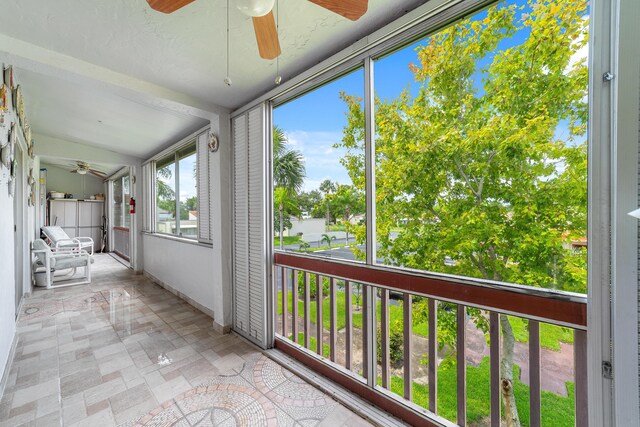 unfurnished sunroom featuring a ceiling fan