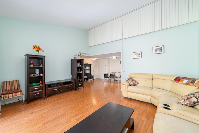 living room with light wood-style flooring and a high ceiling