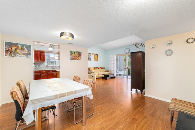 dining space with light wood-style floors, visible vents, and baseboards