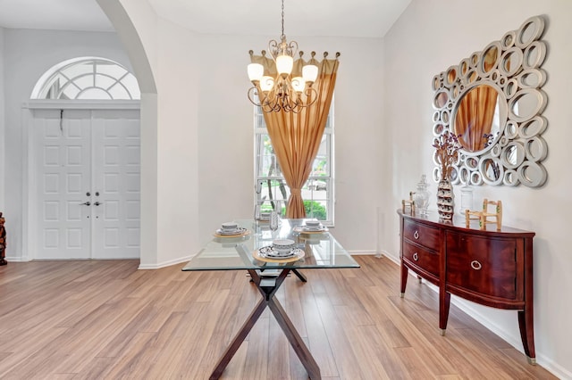 19035 Cypress Crik Ct, Boca Raton, FL 33498 - entryway featuring baseboards, arched walkways, a chandelier, and light wood-style flooring