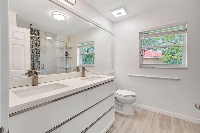 bathroom with double vanity, a sink, toilet, and a shower stall