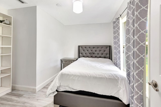 bedroom featuring baseboards and wood finished floors