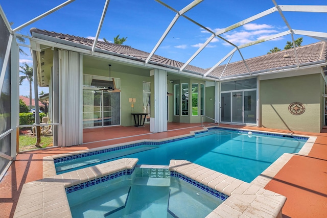 view of pool with glass enclosure, a patio area, and a pool with connected hot tub