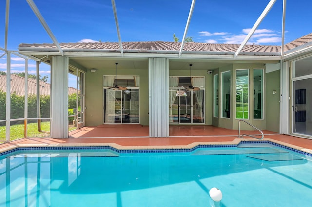 pool with a ceiling fan, a patio area, and glass enclosure